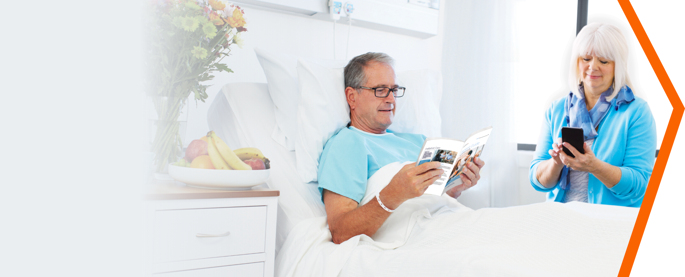 Man and woman reading the patient guide in a hospital room.